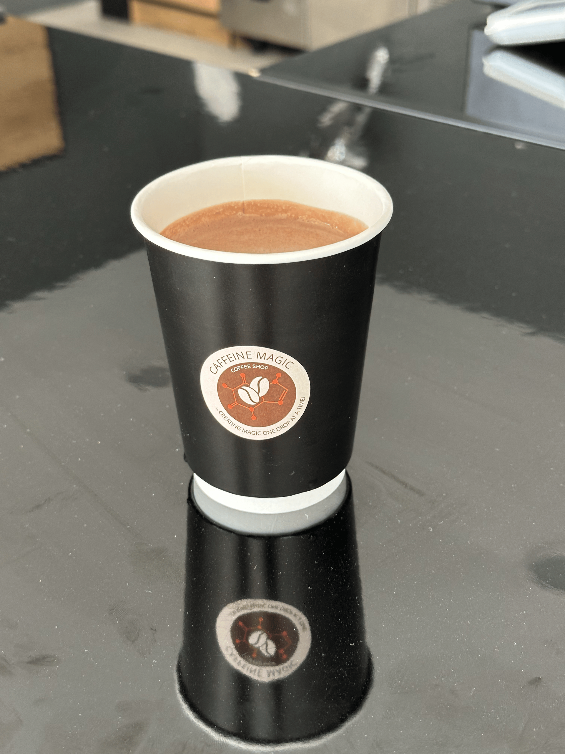 A cup of coffee is sitting on a table.