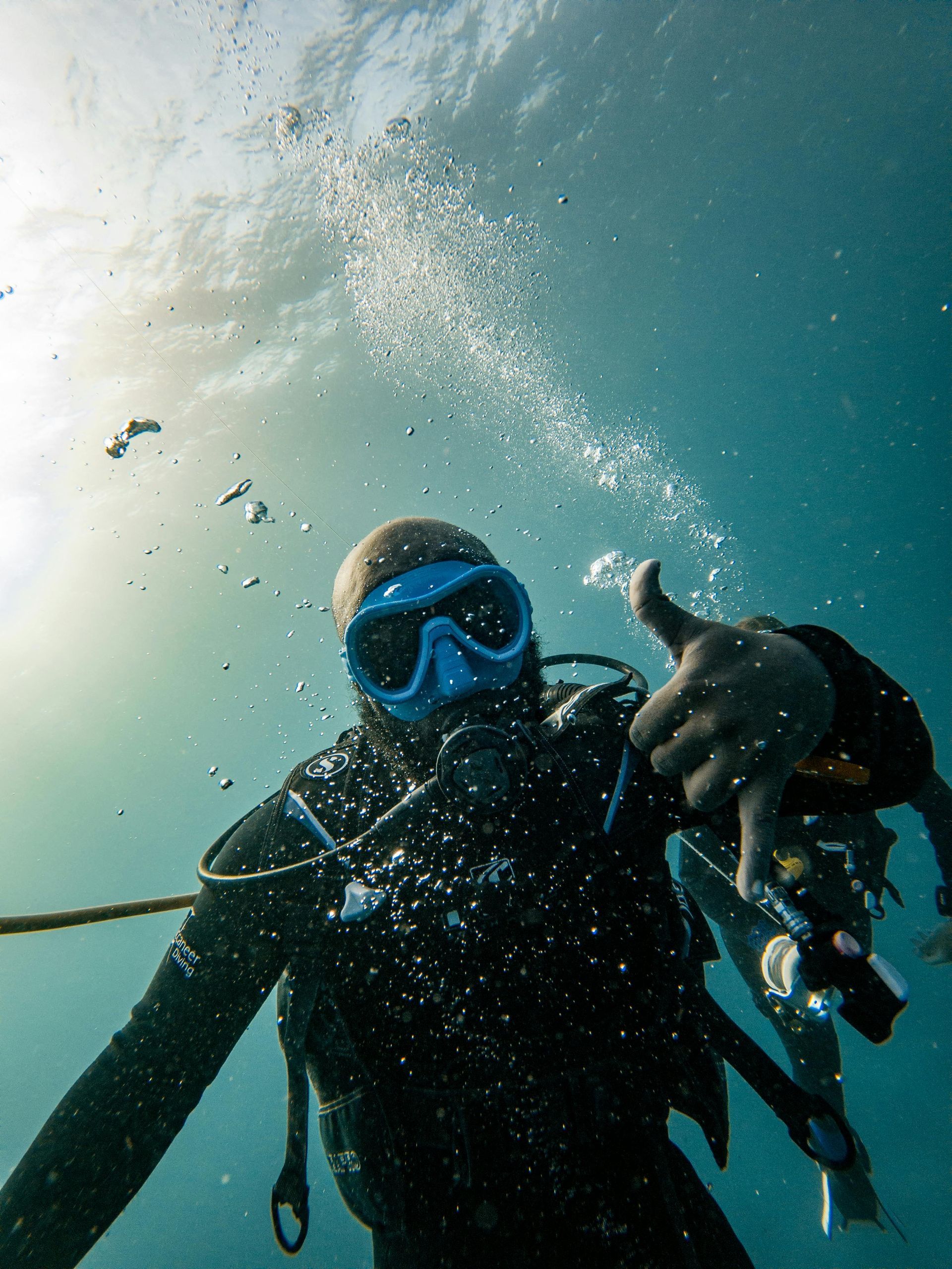 A scuba diver is giving a thumbs up in the ocean