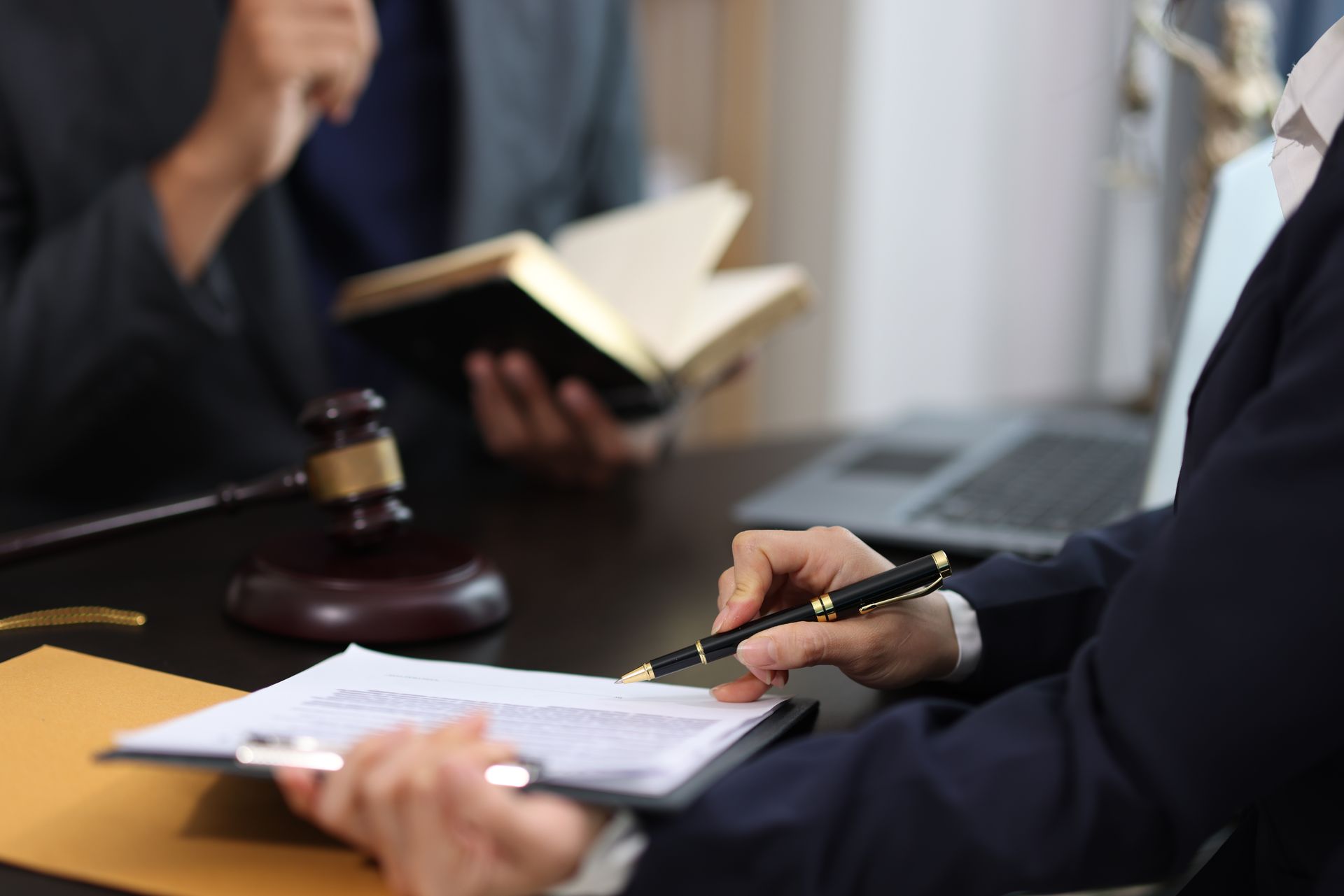 Attorney reviewing legal documents beside gavel and law book.