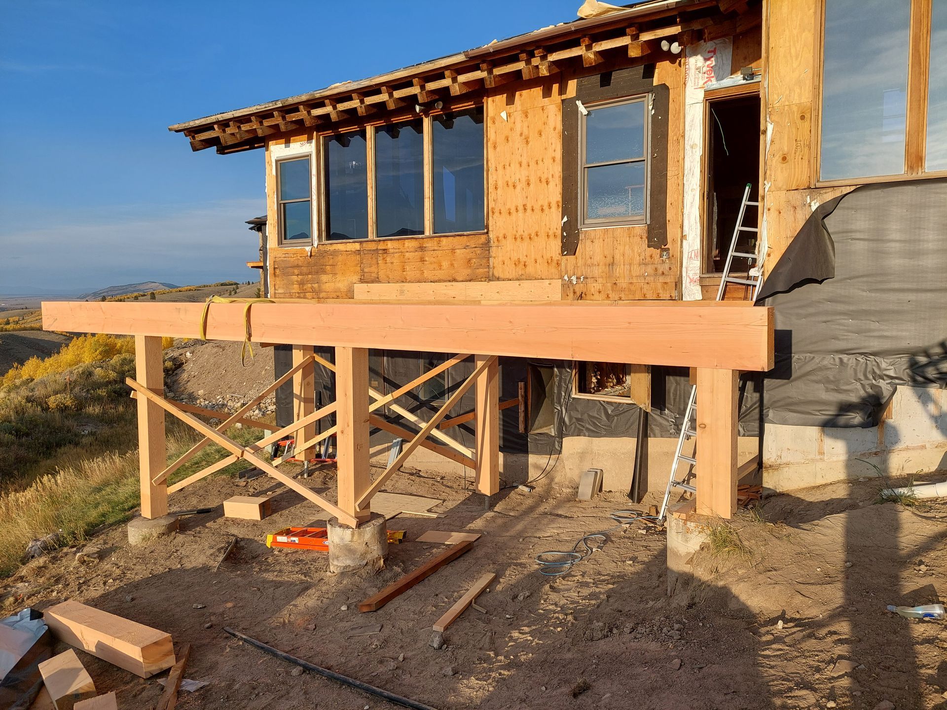 A house is being built on stilts with a wooden deck