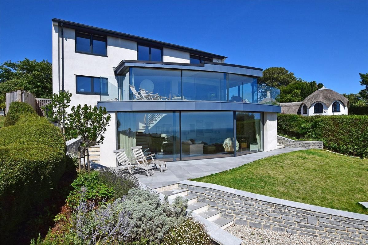 a house with a glass wall and a patio