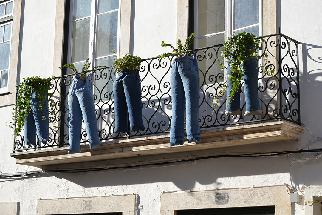 A balcony with blue jeans hanging from it