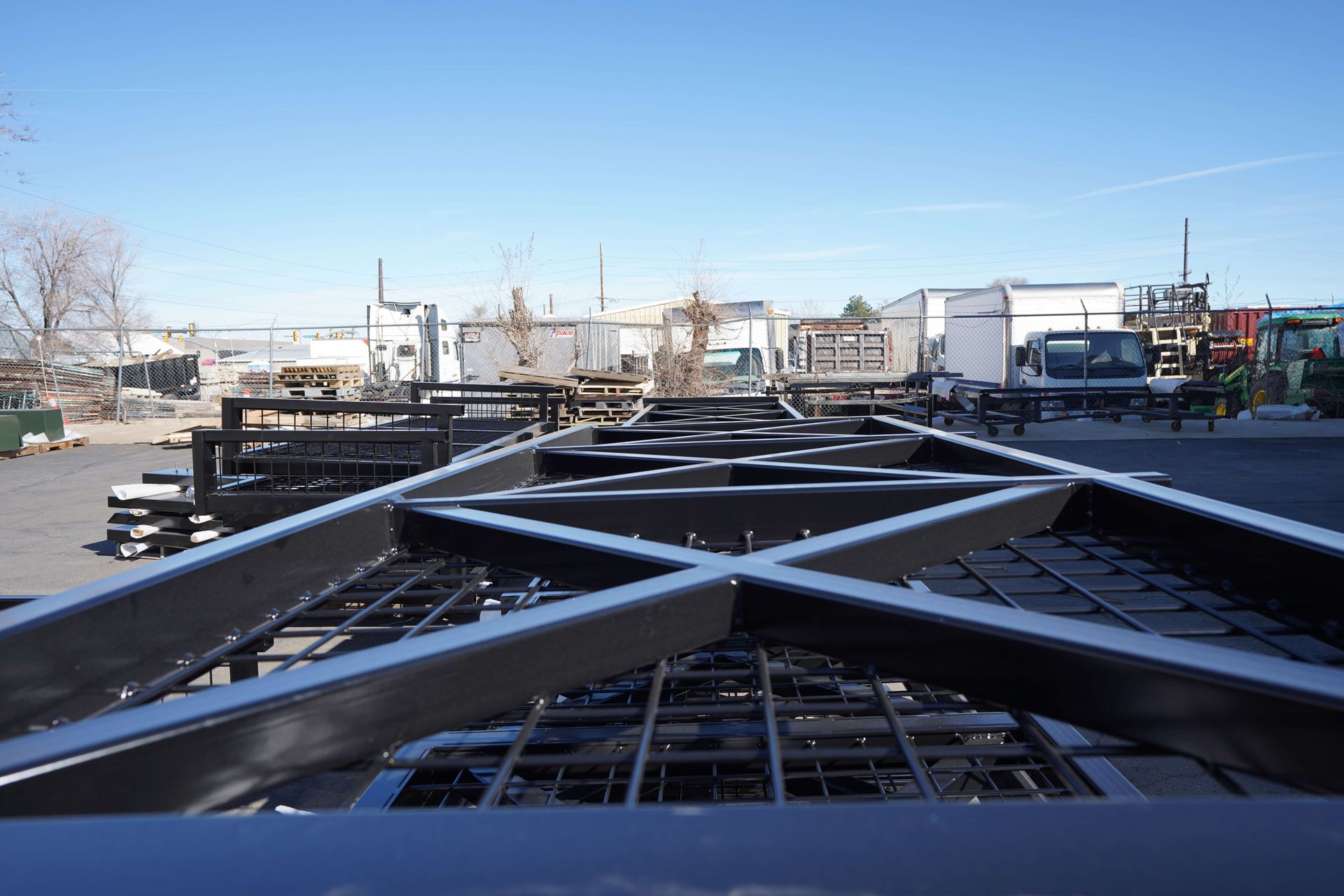 A metal structure is sitting in a parking lot with a blue sky in the background.