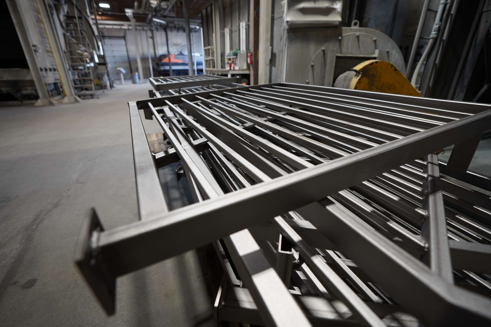 A metal staircase is sitting on top of a conveyor belt in a factory.