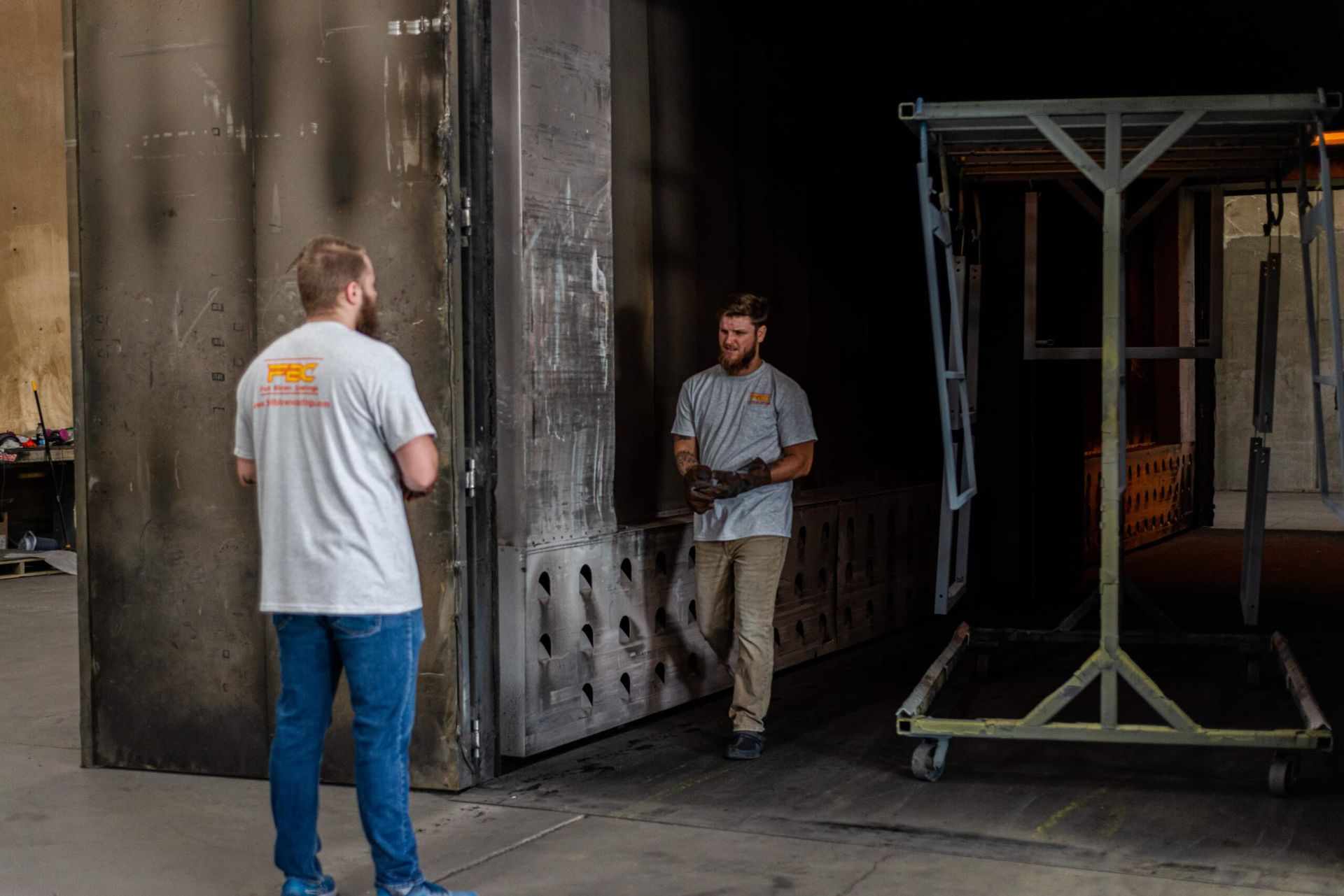 Two men are standing next to each other in a warehouse.