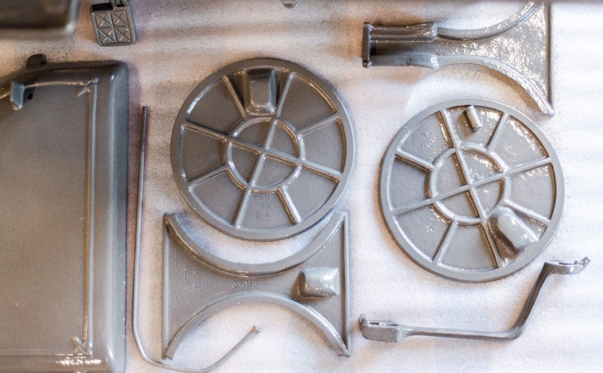 A bunch of metal parts are laying on a white surface.