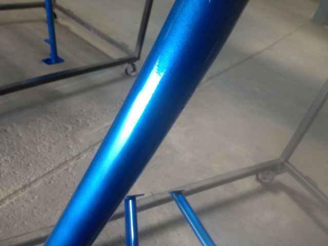 A close up of a blue metal pole on a tiled floor.