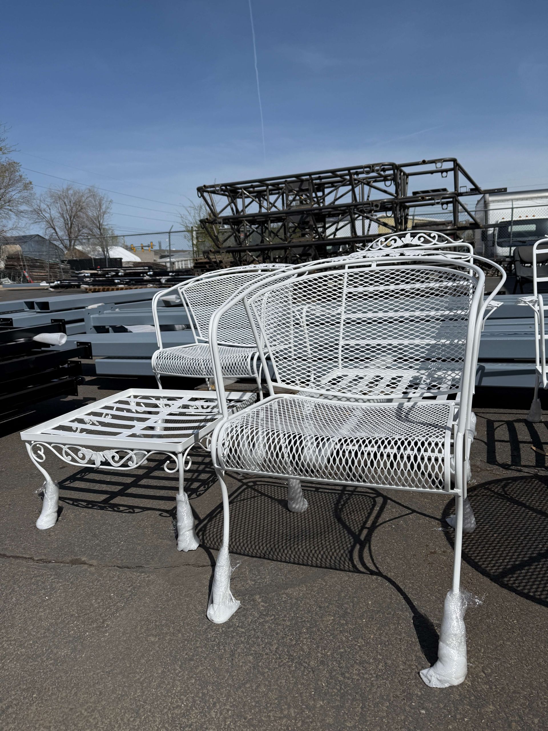 A bunch of white chairs are sitting on the ground in a parking lot.