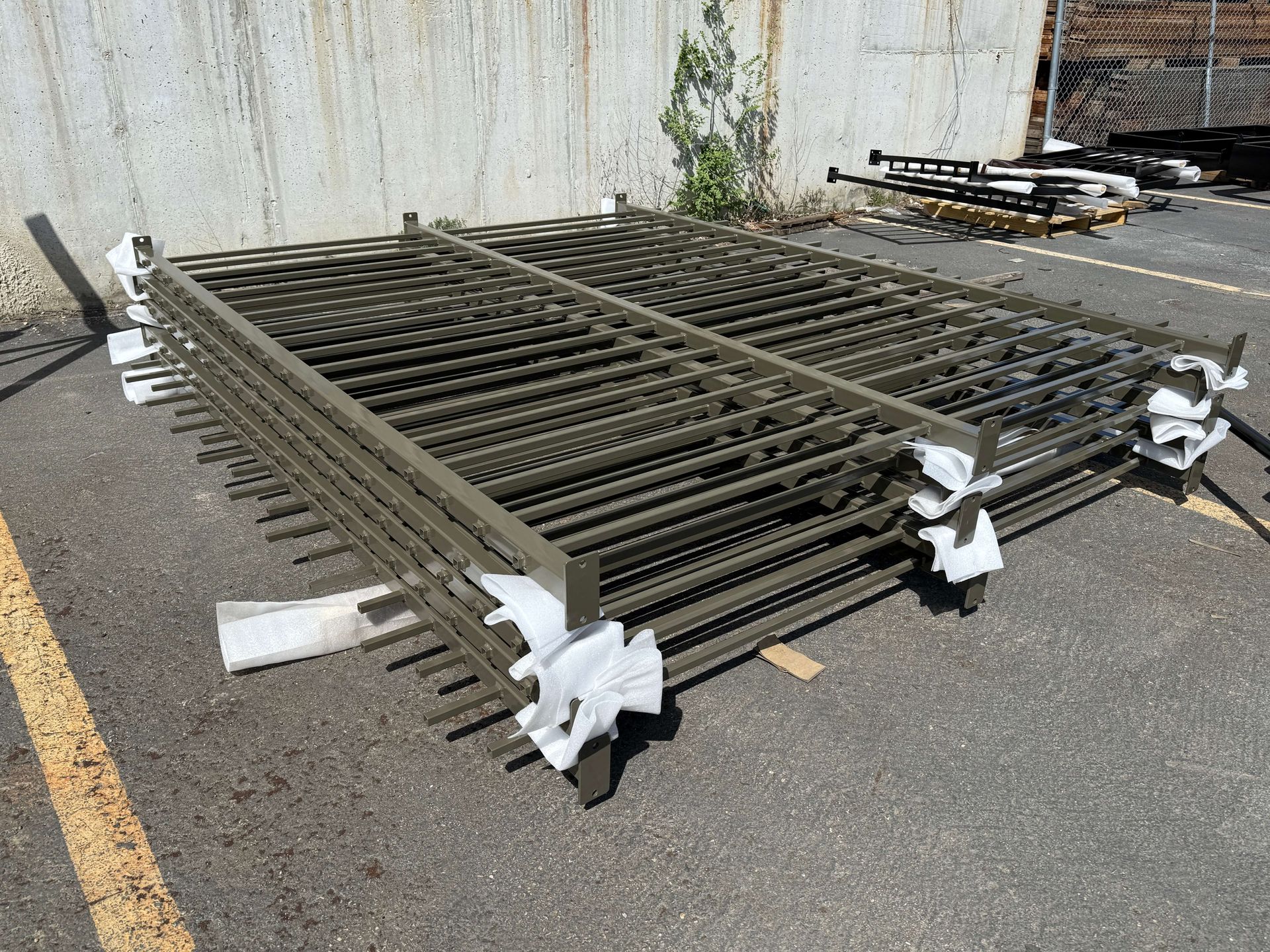 A stack of sand blasted metal fences sitting on top of each other in a parking lot.