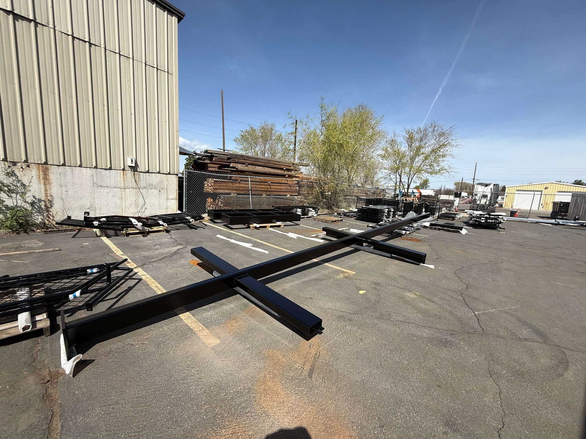 A large powder coated sign holder is sitting in a parking lot in front of a building.