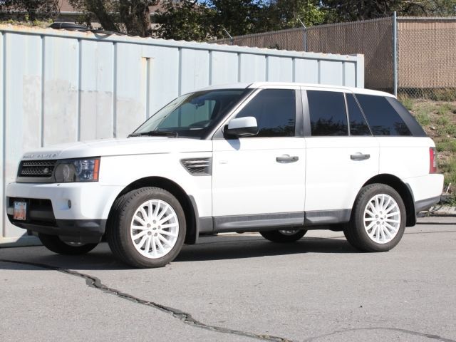 A white range rover is parked in front of a building