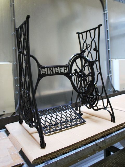 A singer sewing machine sits on a wooden table