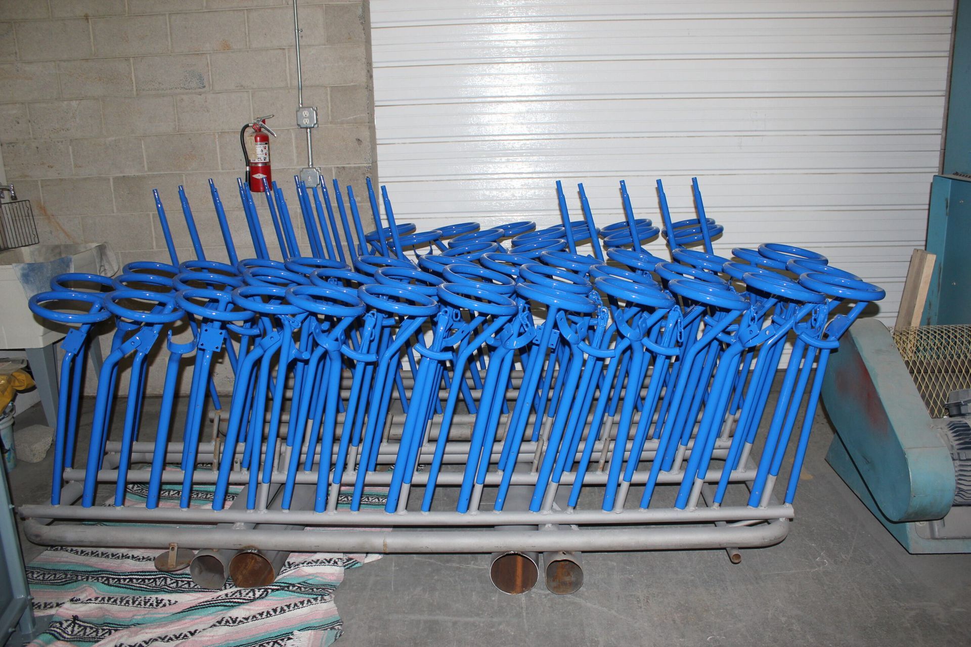 A bunch of blue chairs are stacked on top of each other