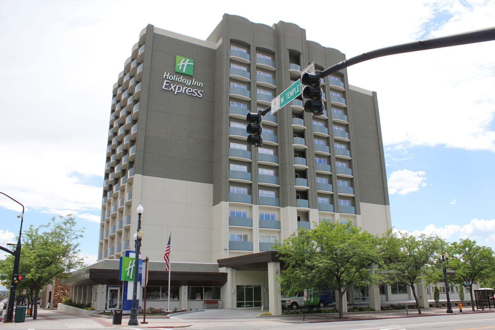 A large hotel is sitting on the corner of a city street.