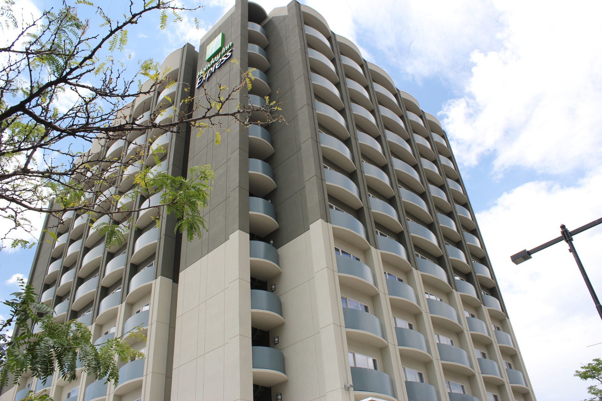 A tall building with a lot of balconies on a sunny day