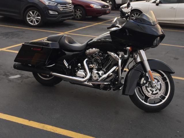 A black harley davidson motorcycle is parked in a parking lot