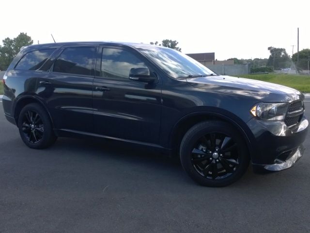 A black dodge durango is parked on the side of the road.