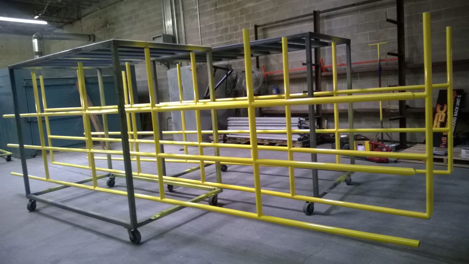 A yellow metal fence is sitting in a warehouse.