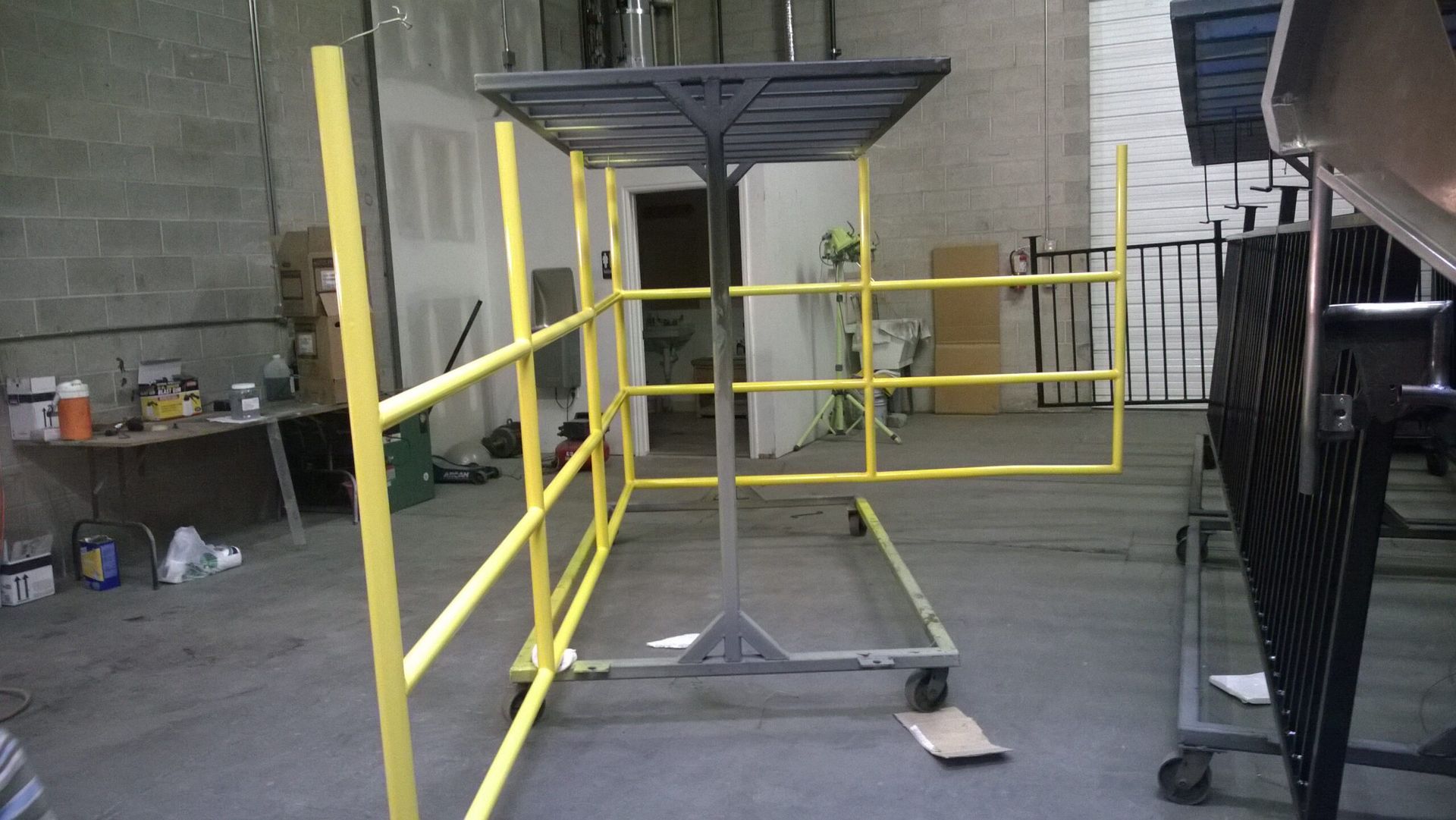 A yellow scaffolding with wheels is in a room