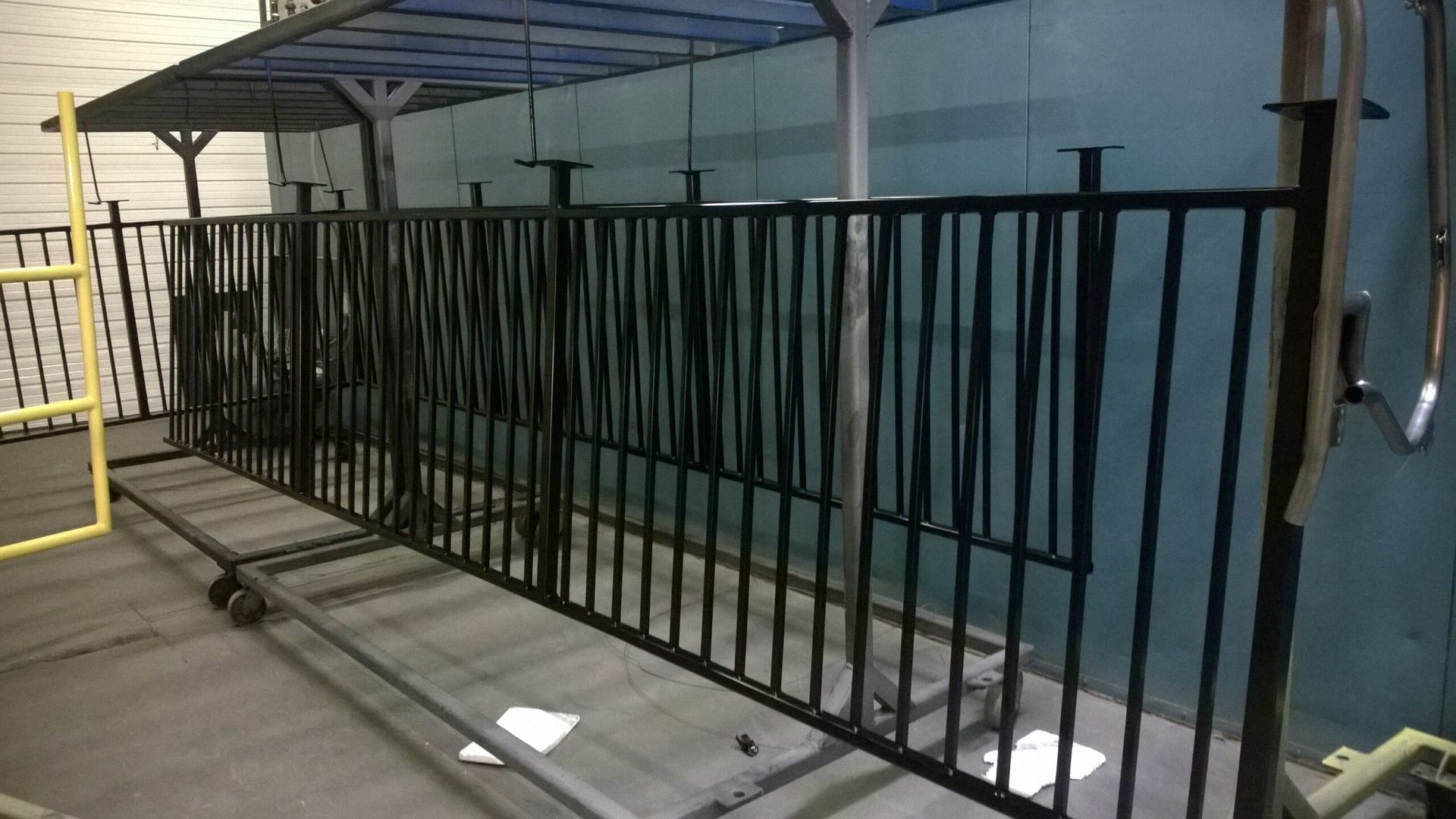 A black metal fence is being painted in a room.