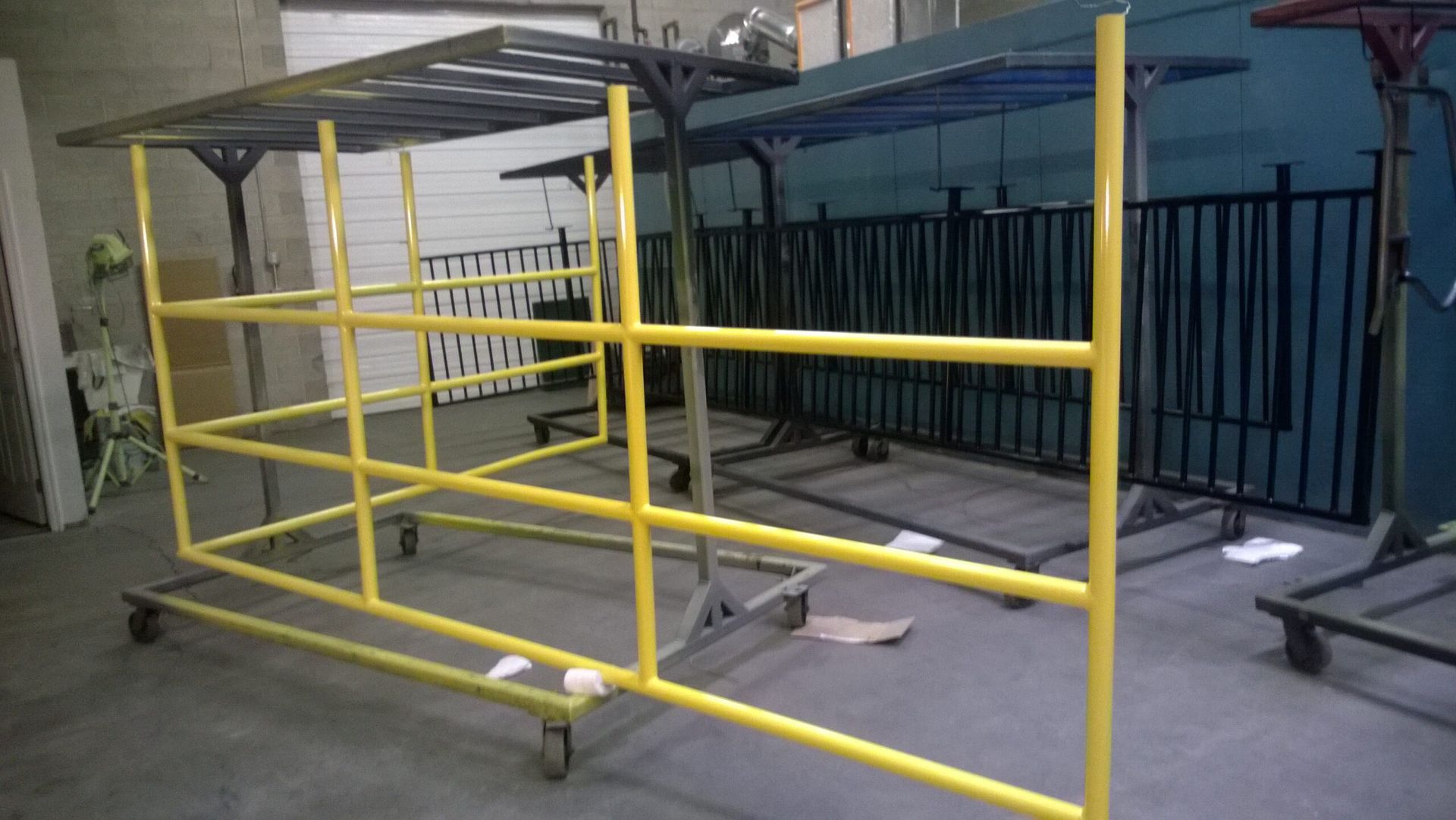 A yellow metal structure with wheels is sitting in a room.