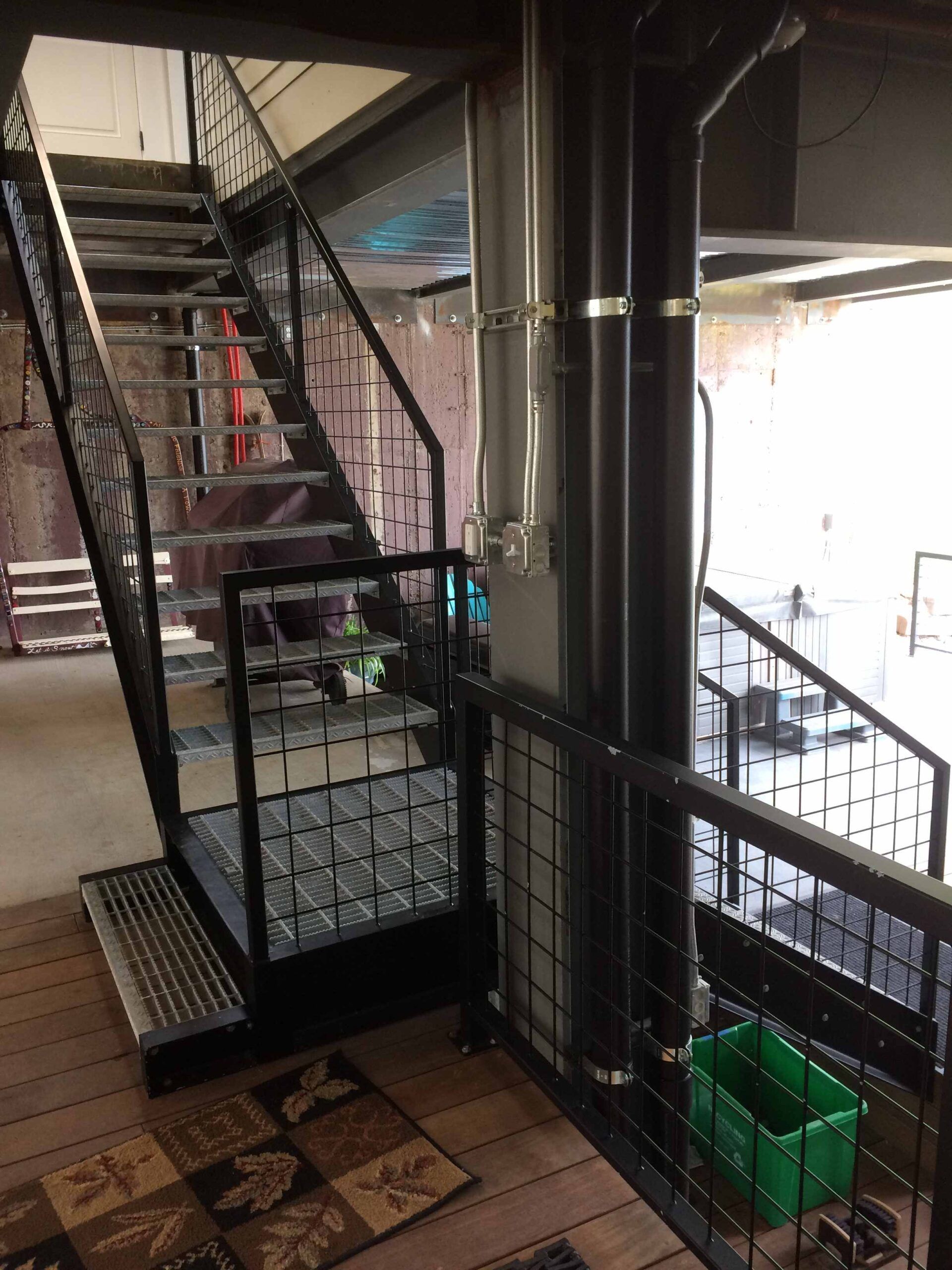 A staircase in a building with a green box on the floor