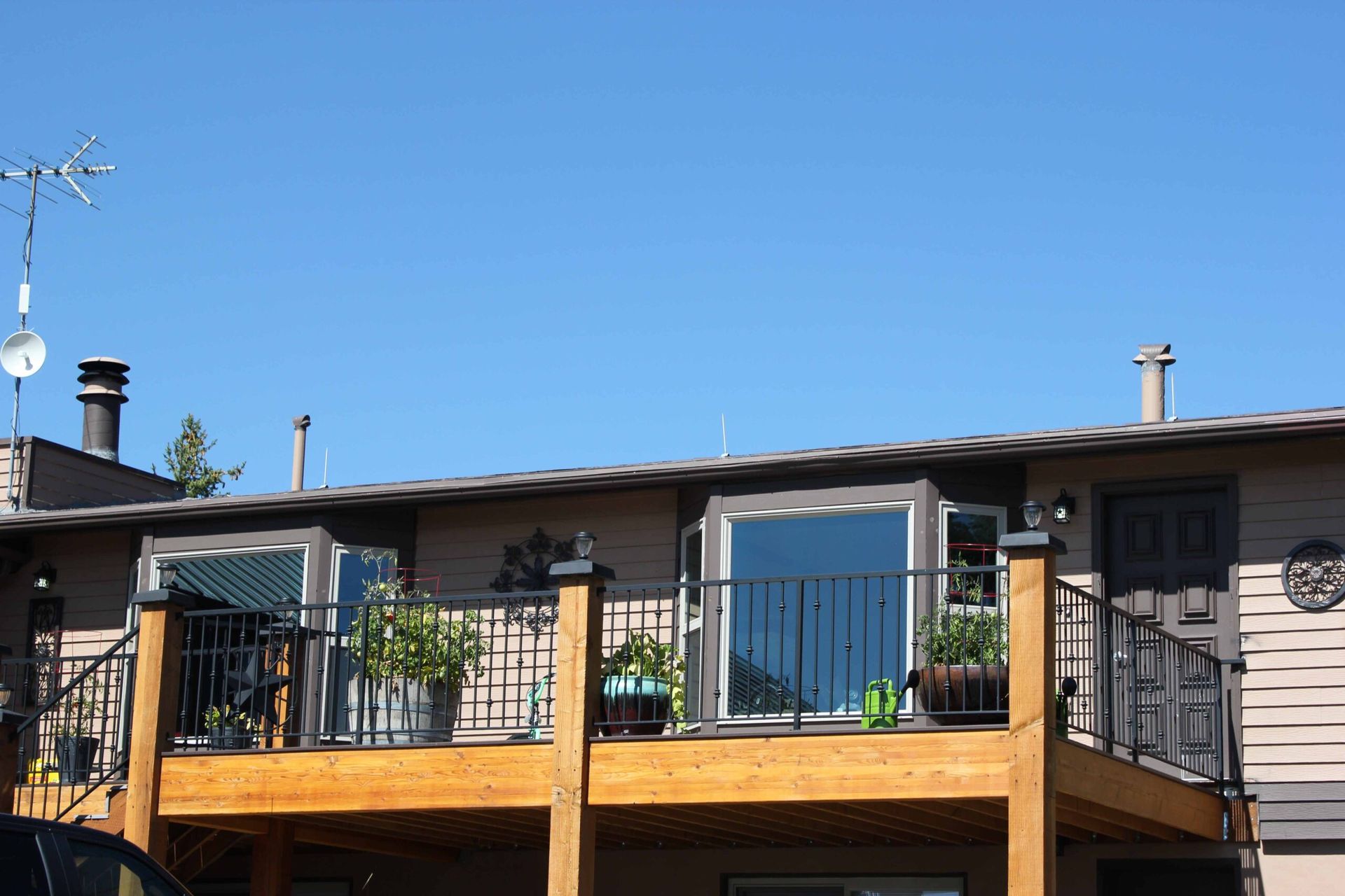 A house with a large deck and a car parked in front of it