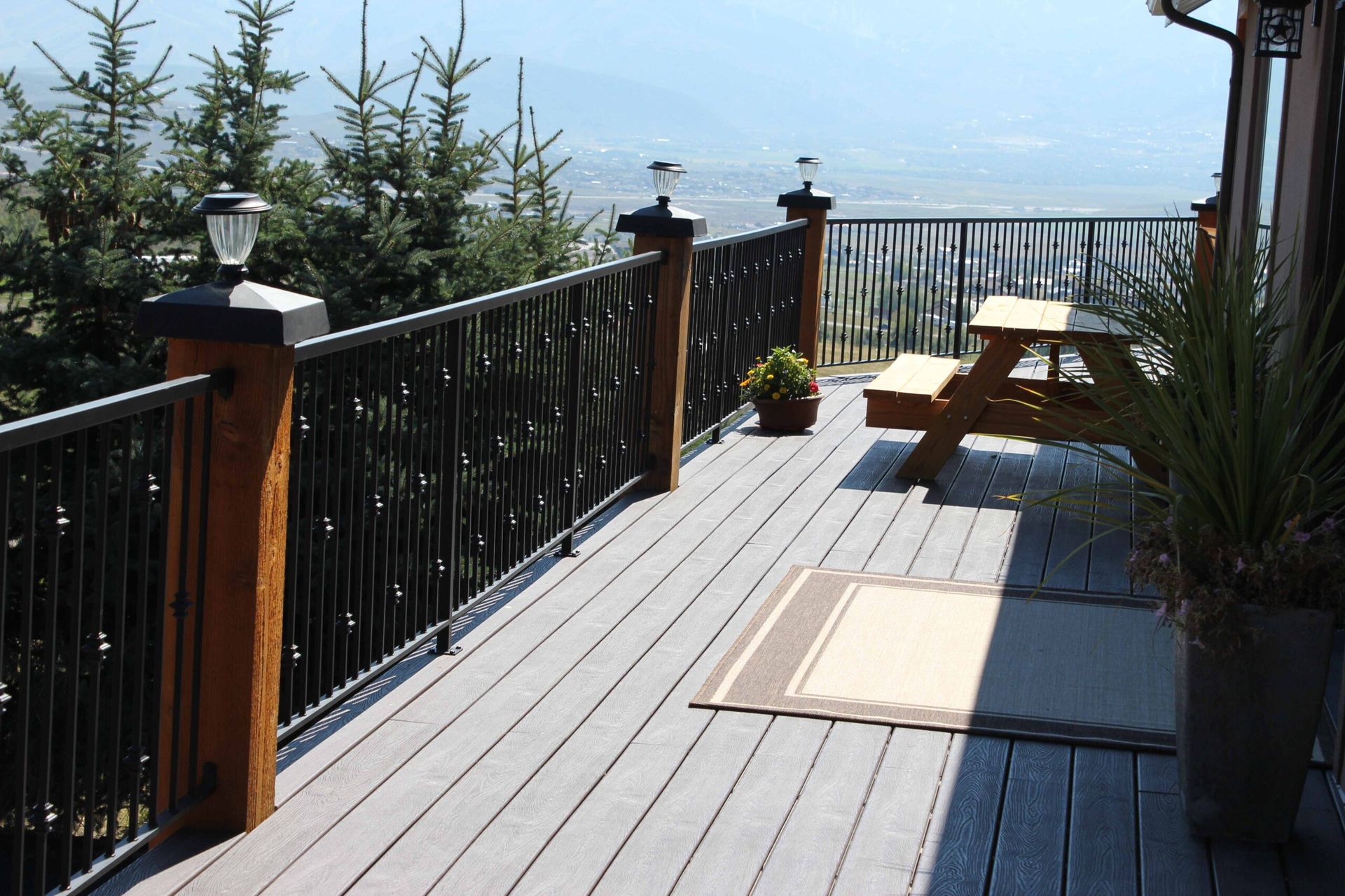 A wooden deck with a metal railing and a picnic table