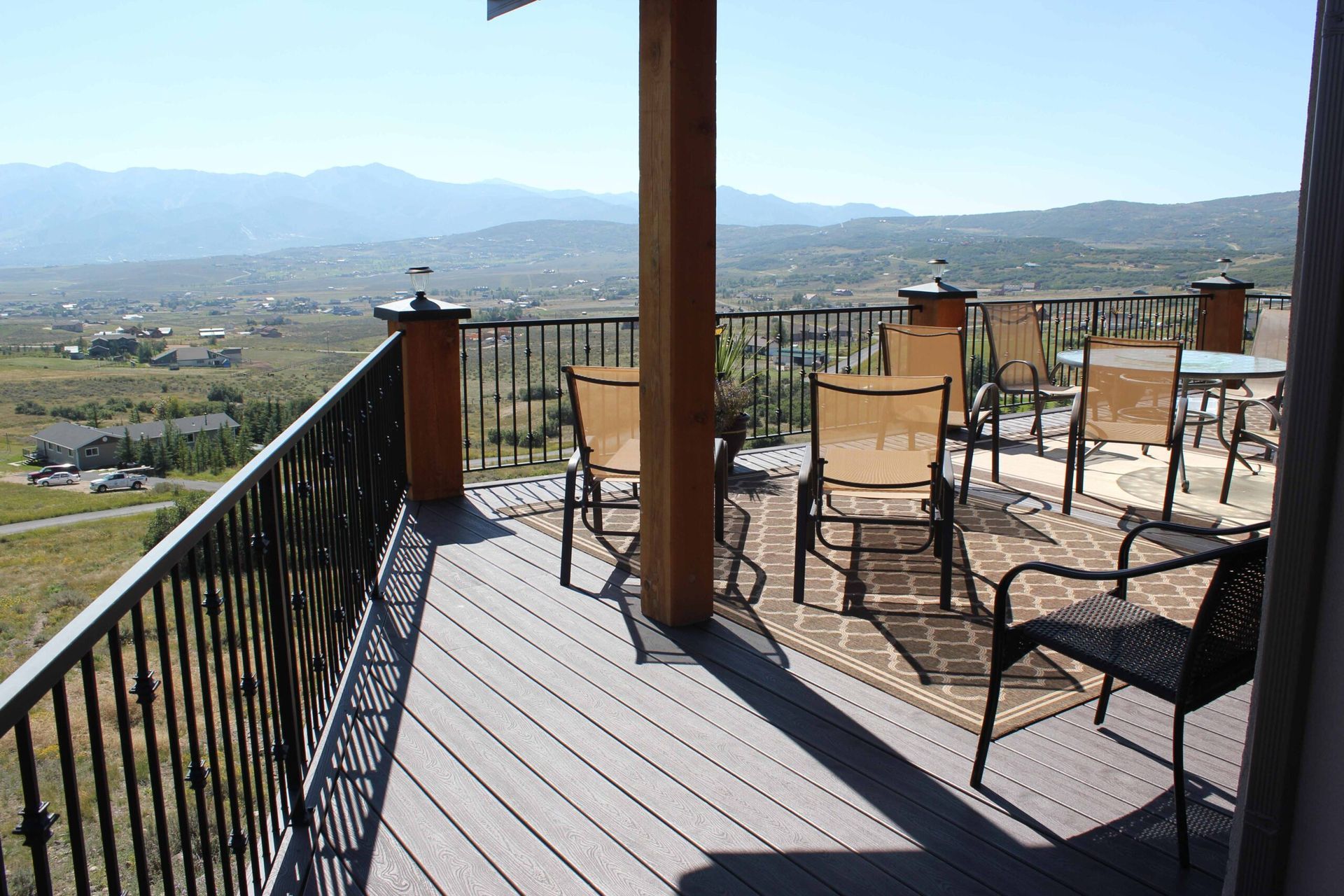 A deck with chairs and a table with a view of the mountains