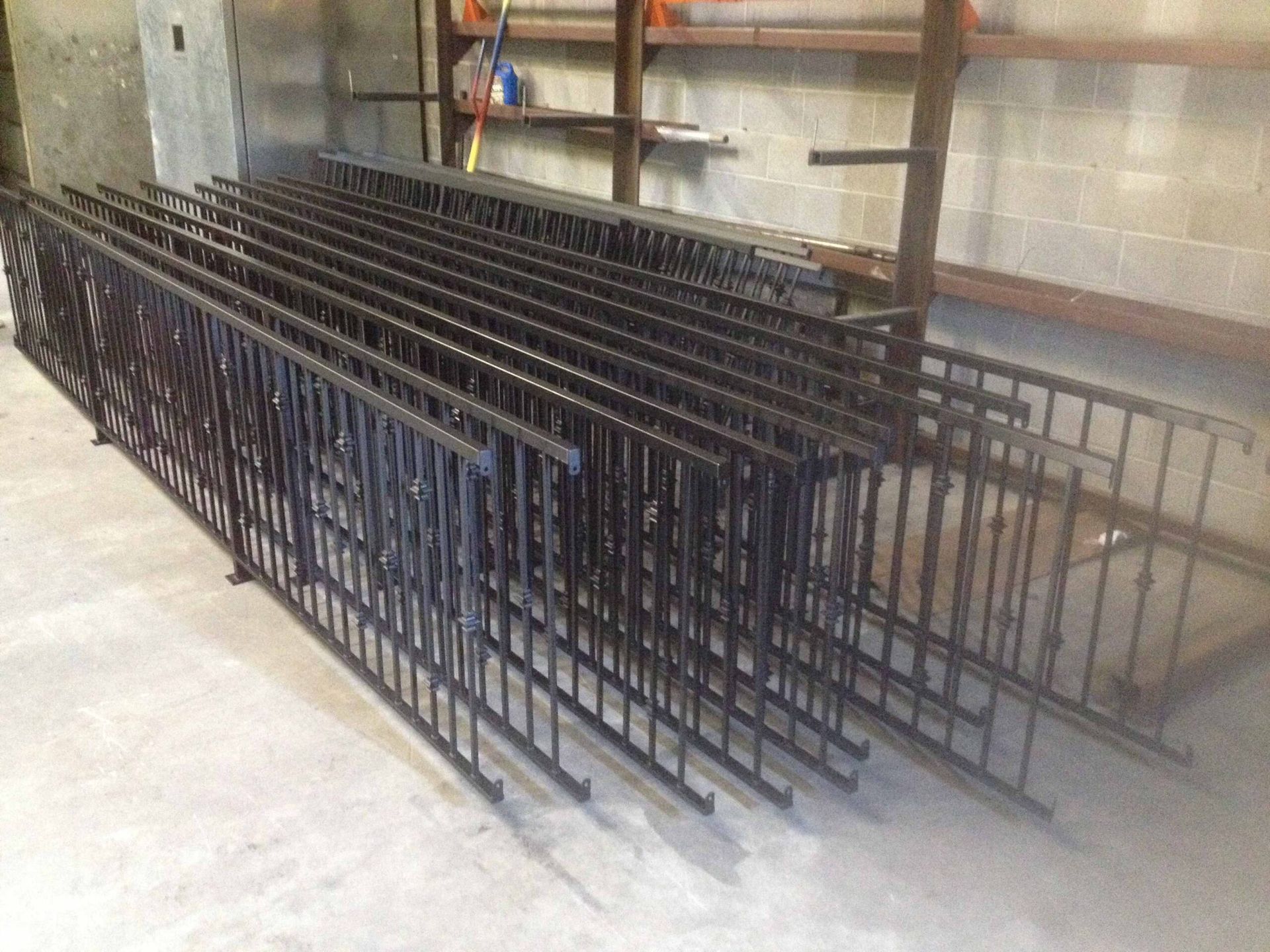A bunch of metal fences are stacked on top of each other in a room.