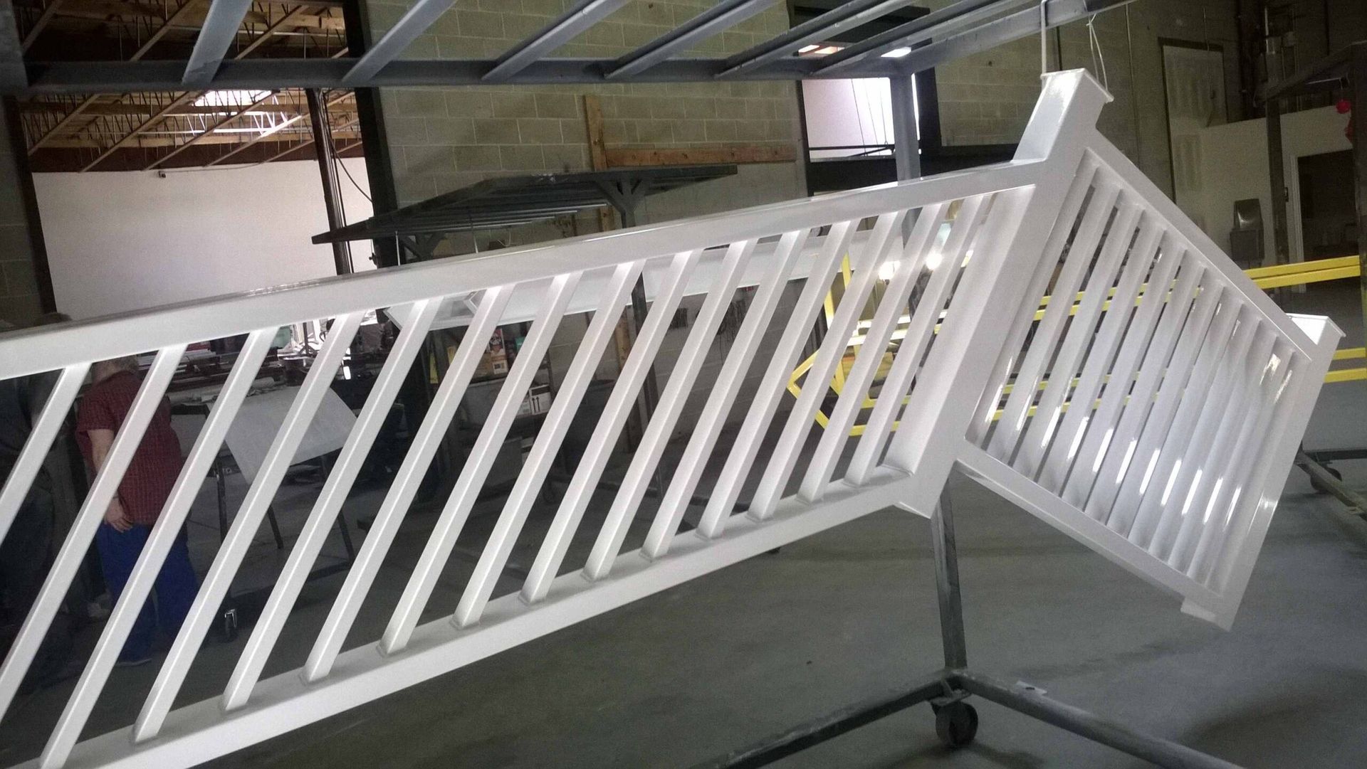 A white railing is sitting on a cart in a room.