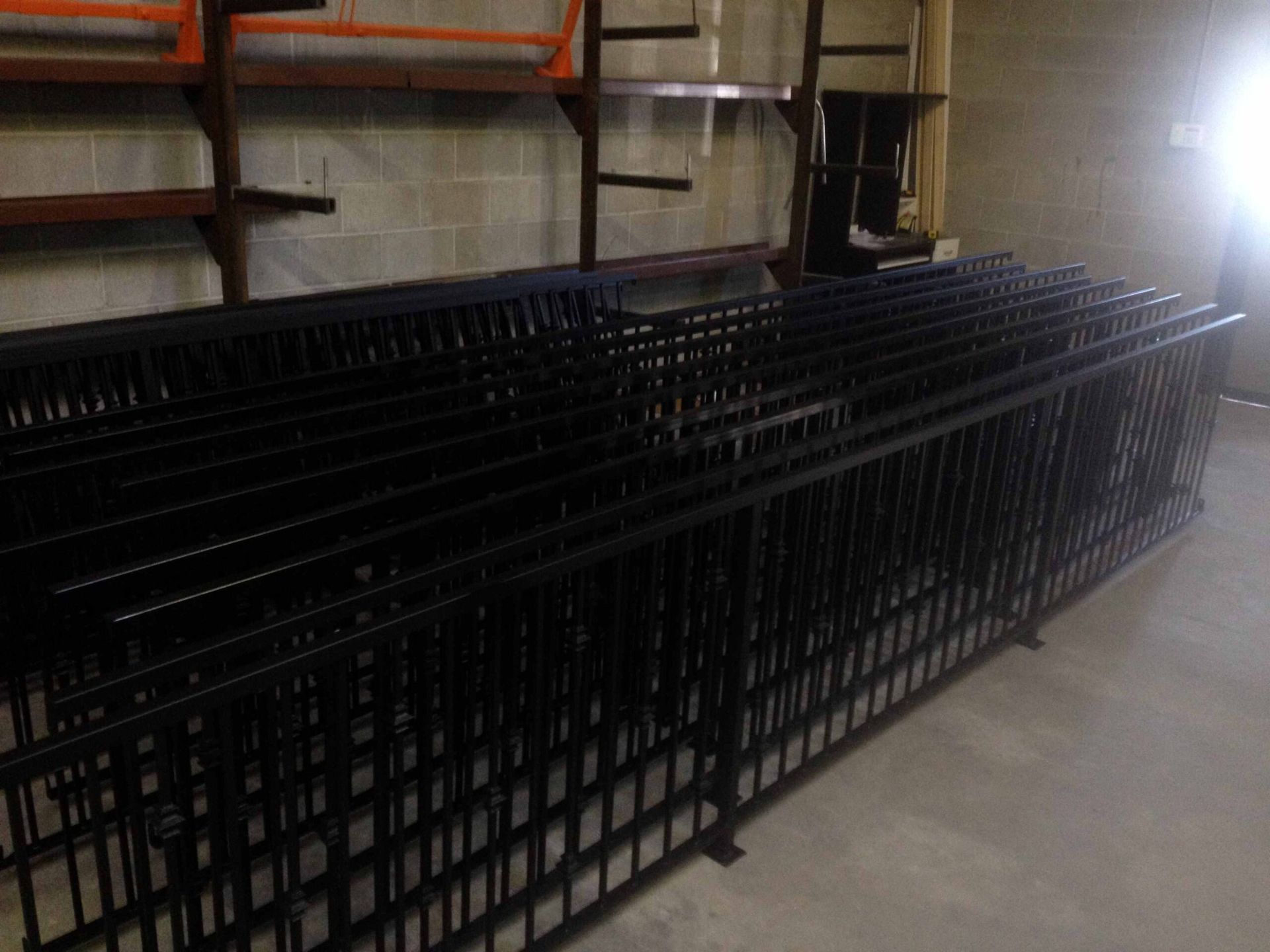 A bunch of metal fences are stacked on top of each other in a room.
