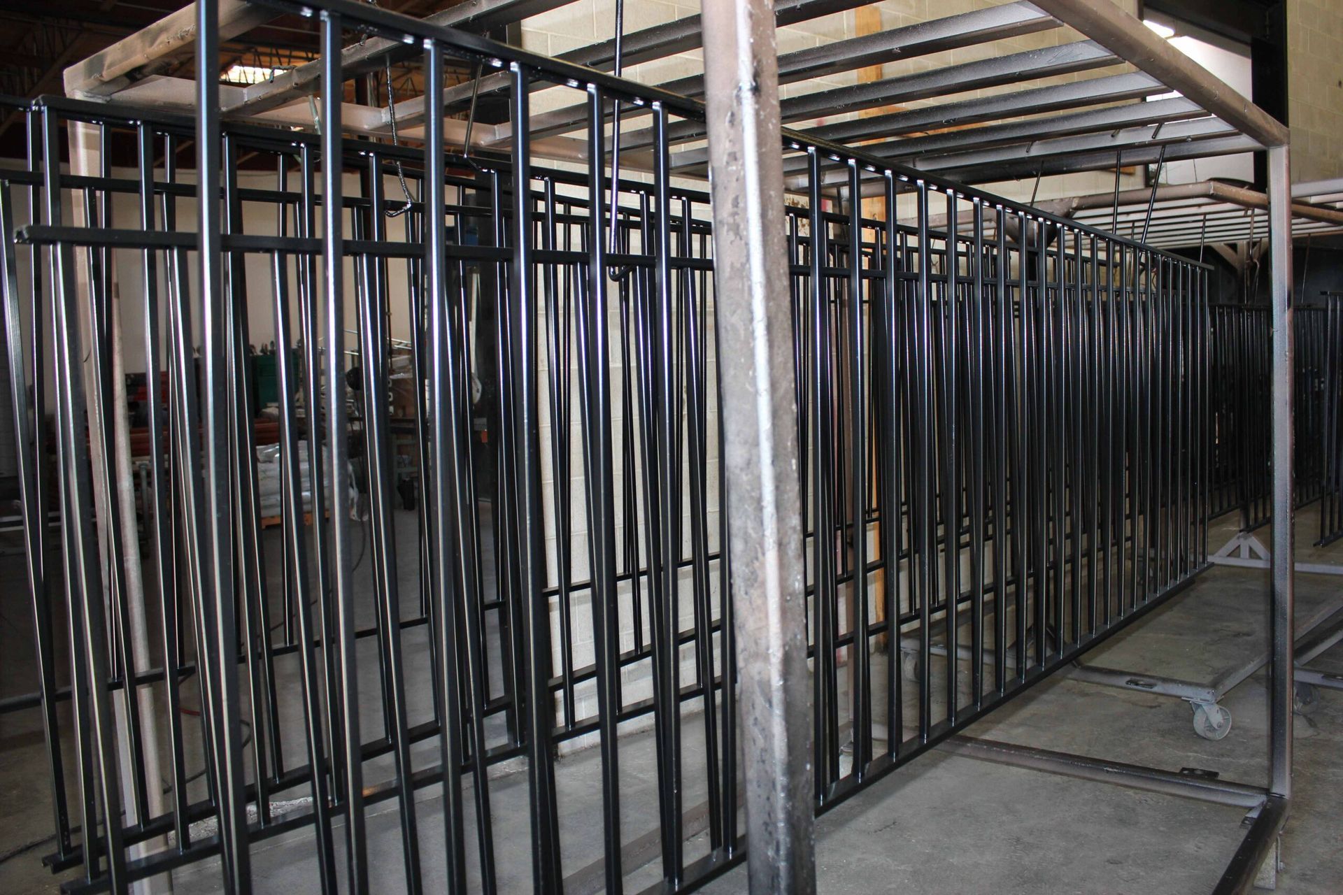 A row of metal fences are lined up in a warehouse