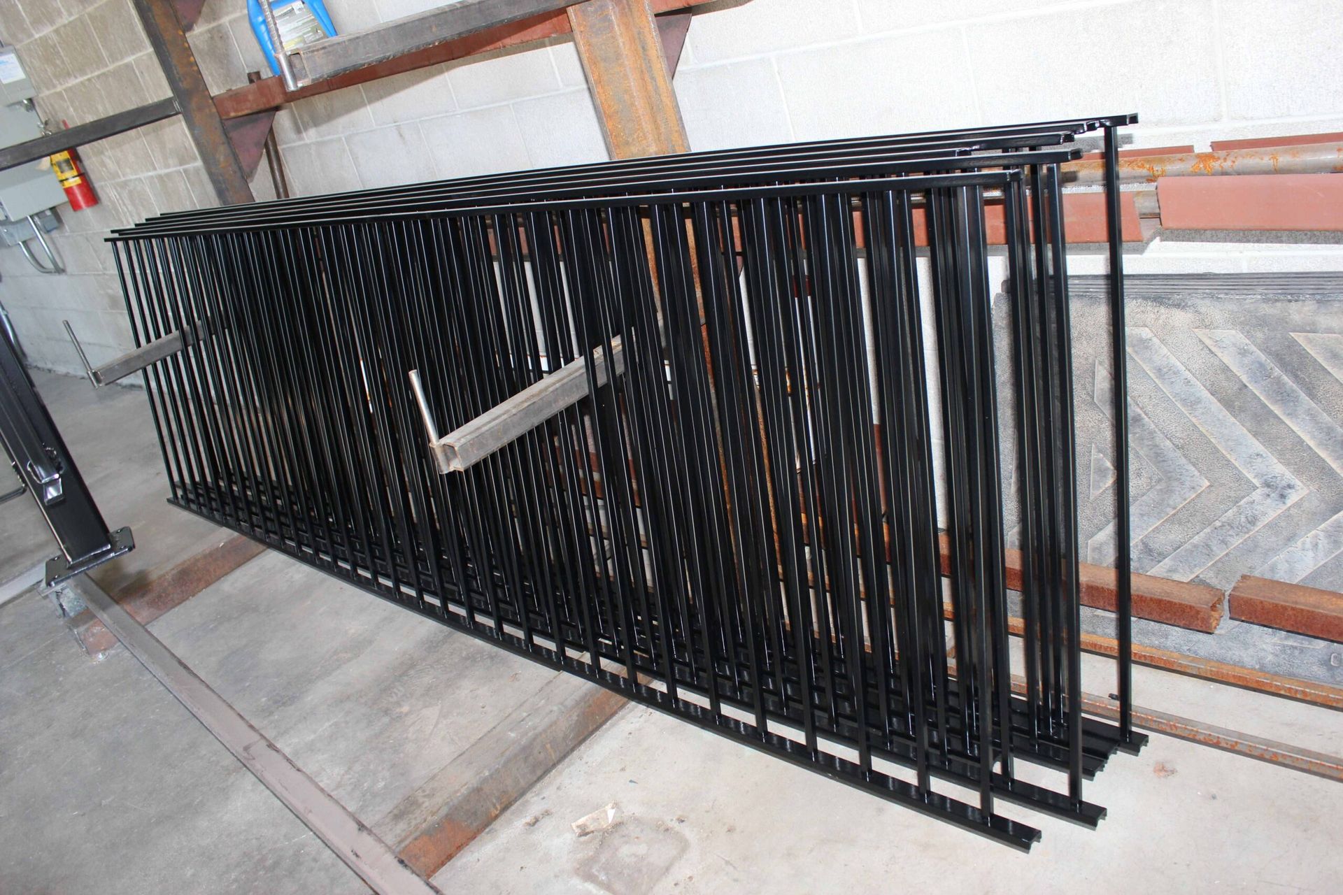 A bunch of black metal fences are stacked on top of each other