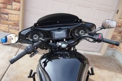 A black motorcycle is parked in front of a garage.