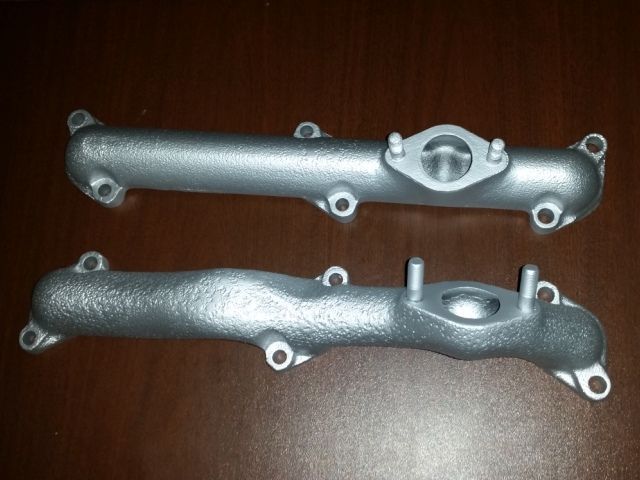 Two metal pipes are sitting on a wooden table