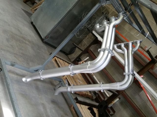 A metal pipe is sitting on a wooden table