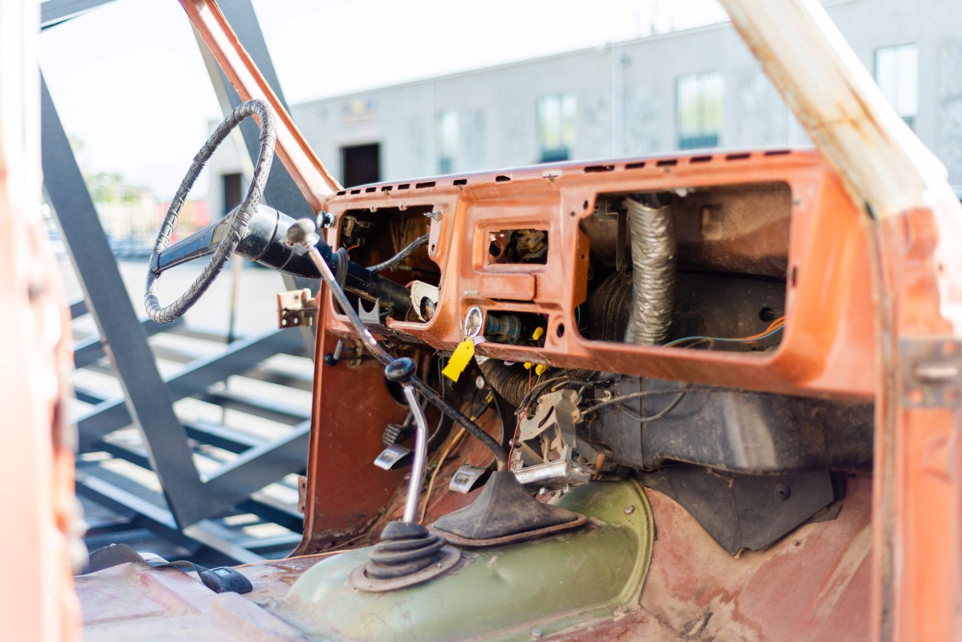 The inside of an old rusty car with the door open.