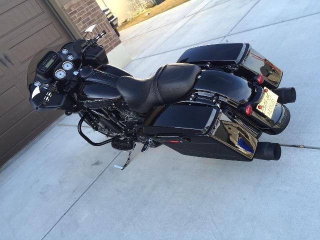 A black harley davidson motorcycle is parked on the sidewalk