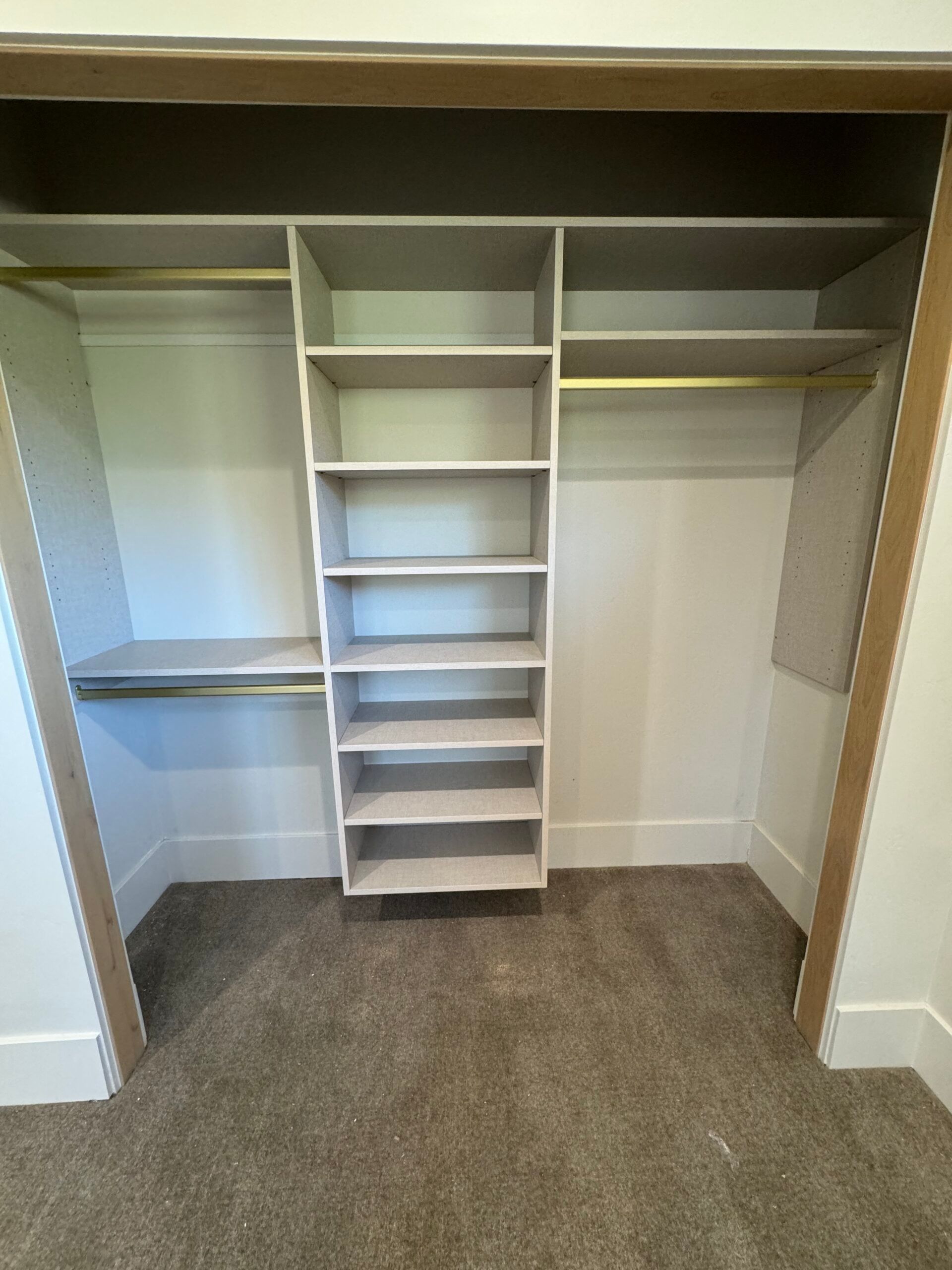 A closet with a lot of shelves and a carpeted floor.