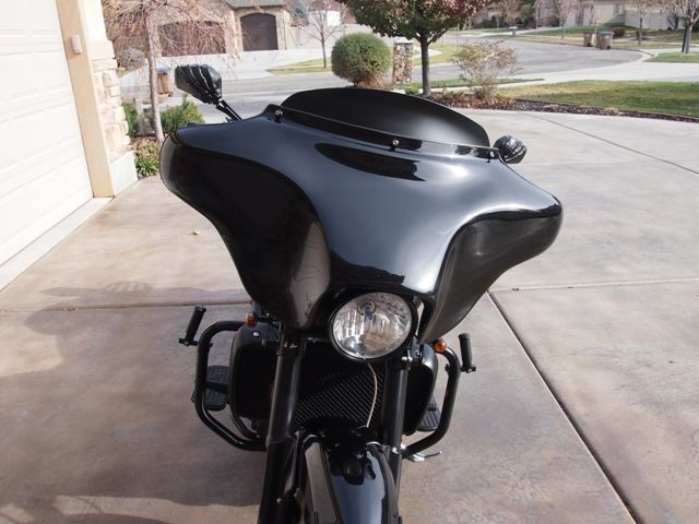 A black motorcycle is parked in front of a garage