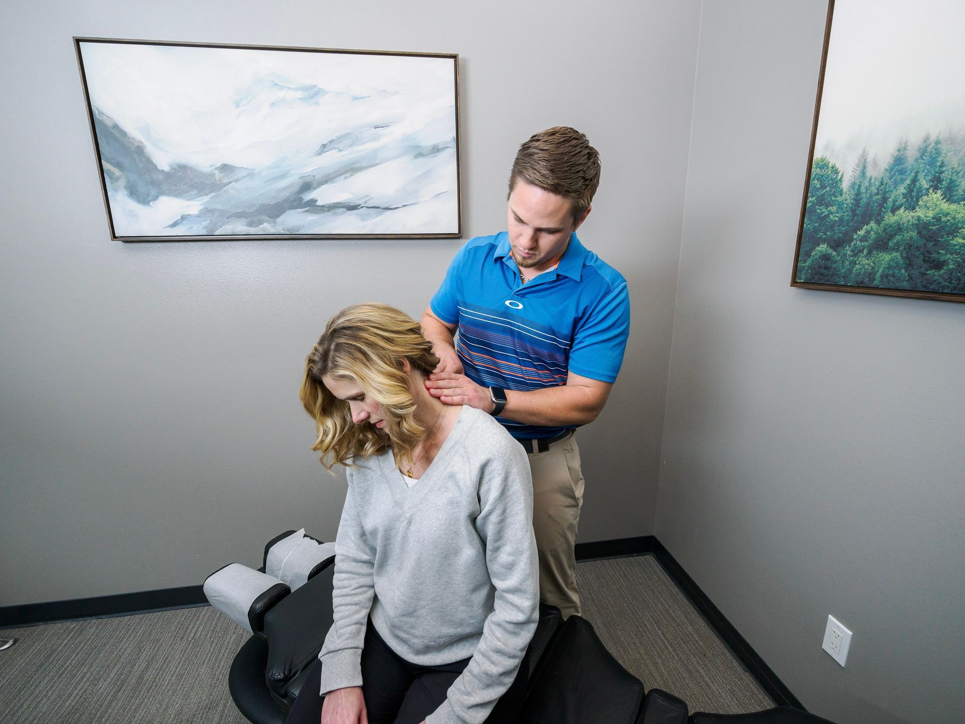 A man is giving a woman a neck massage in a room.