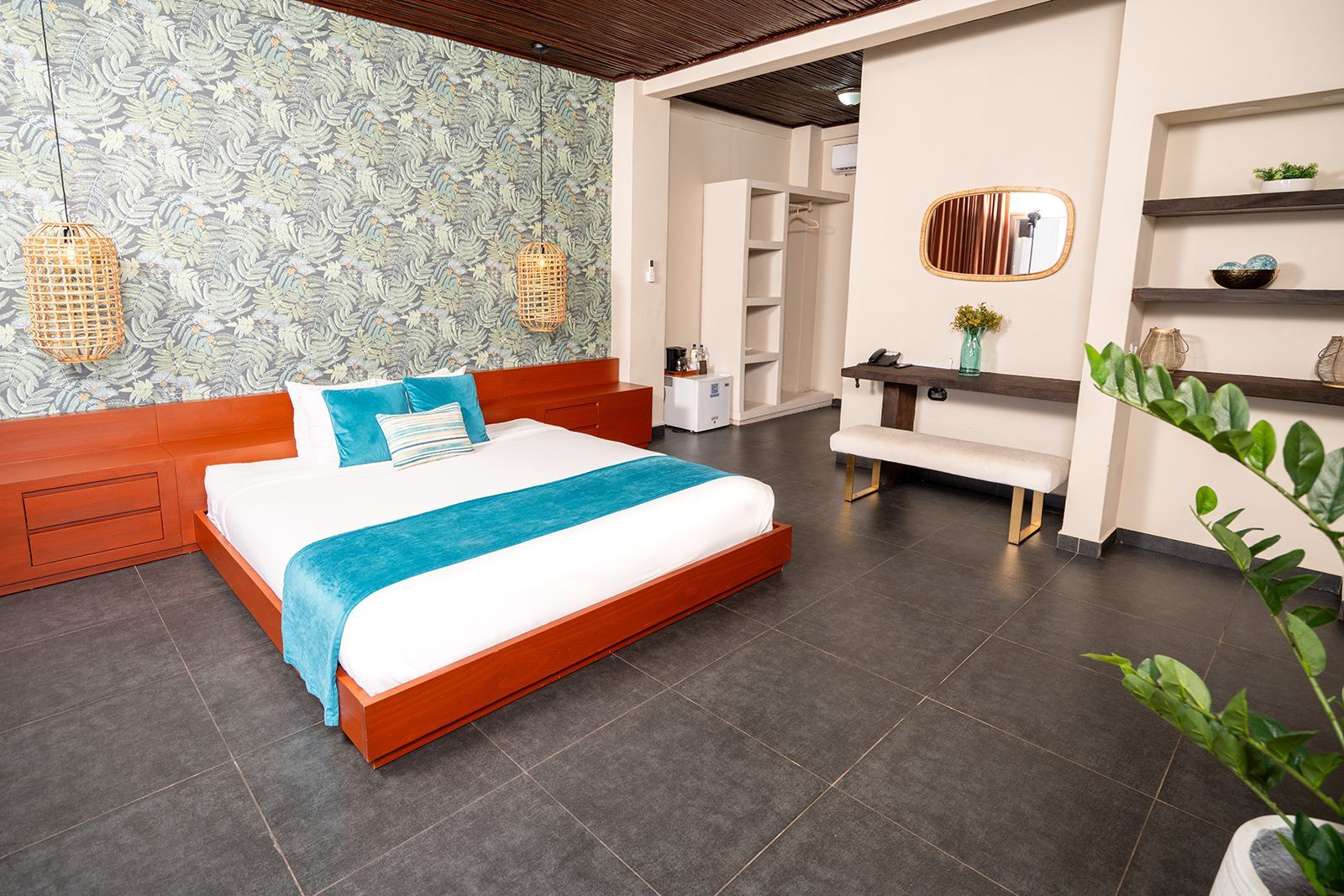 A modern bedroom with a platform bed, patterned wallpaper, a desk, and shelves, featuring a teal runner and gray flooring.