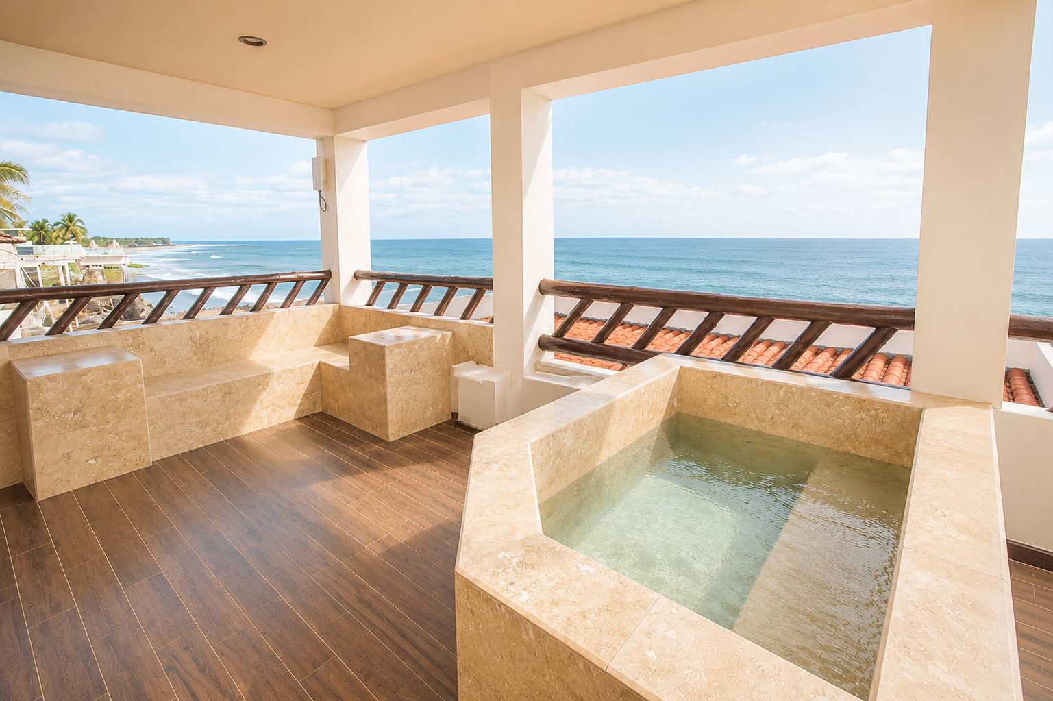 Seaside patio with a hot tub, ocean view, and wooden deck under a shaded roof