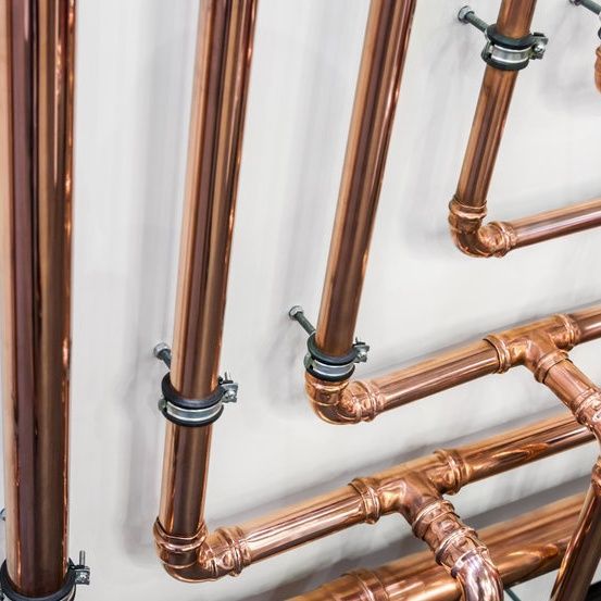 A bunch of copper pipes hanging on a wall
