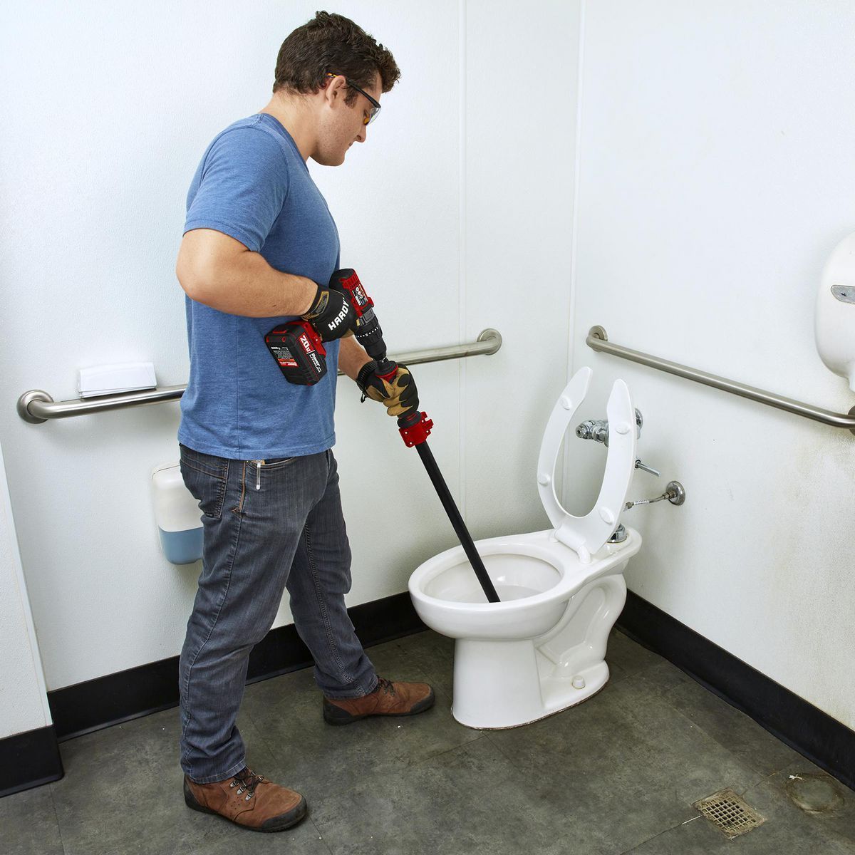 A man is cleaning a toilet with a plunger.