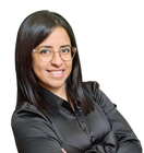 Woman with dark hair, glasses, and a smile wearing a black turtleneck.