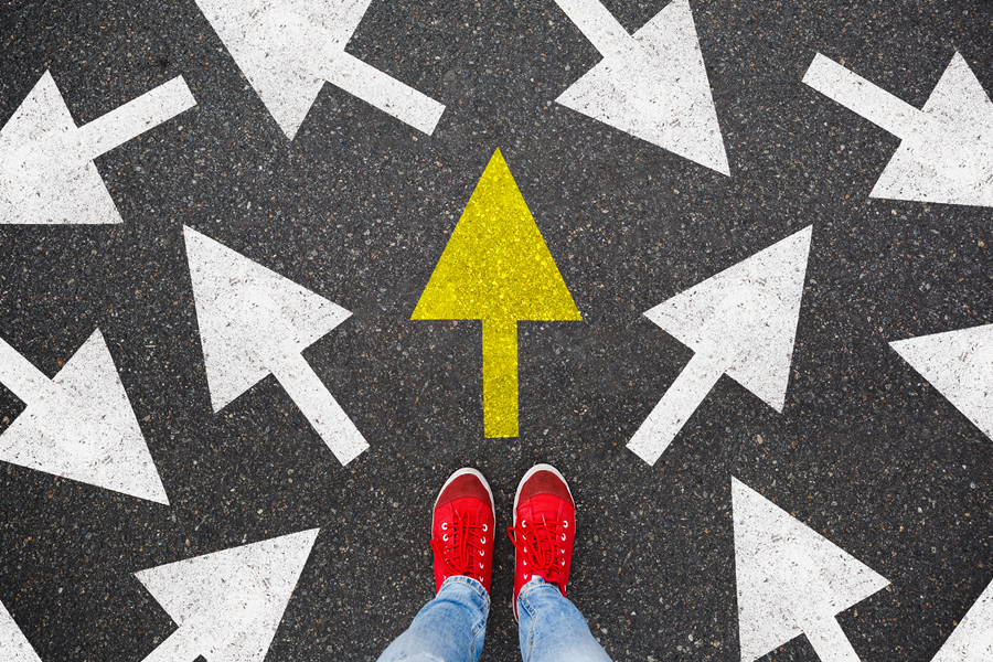 A person standing in front of a yellow arrow pointing up