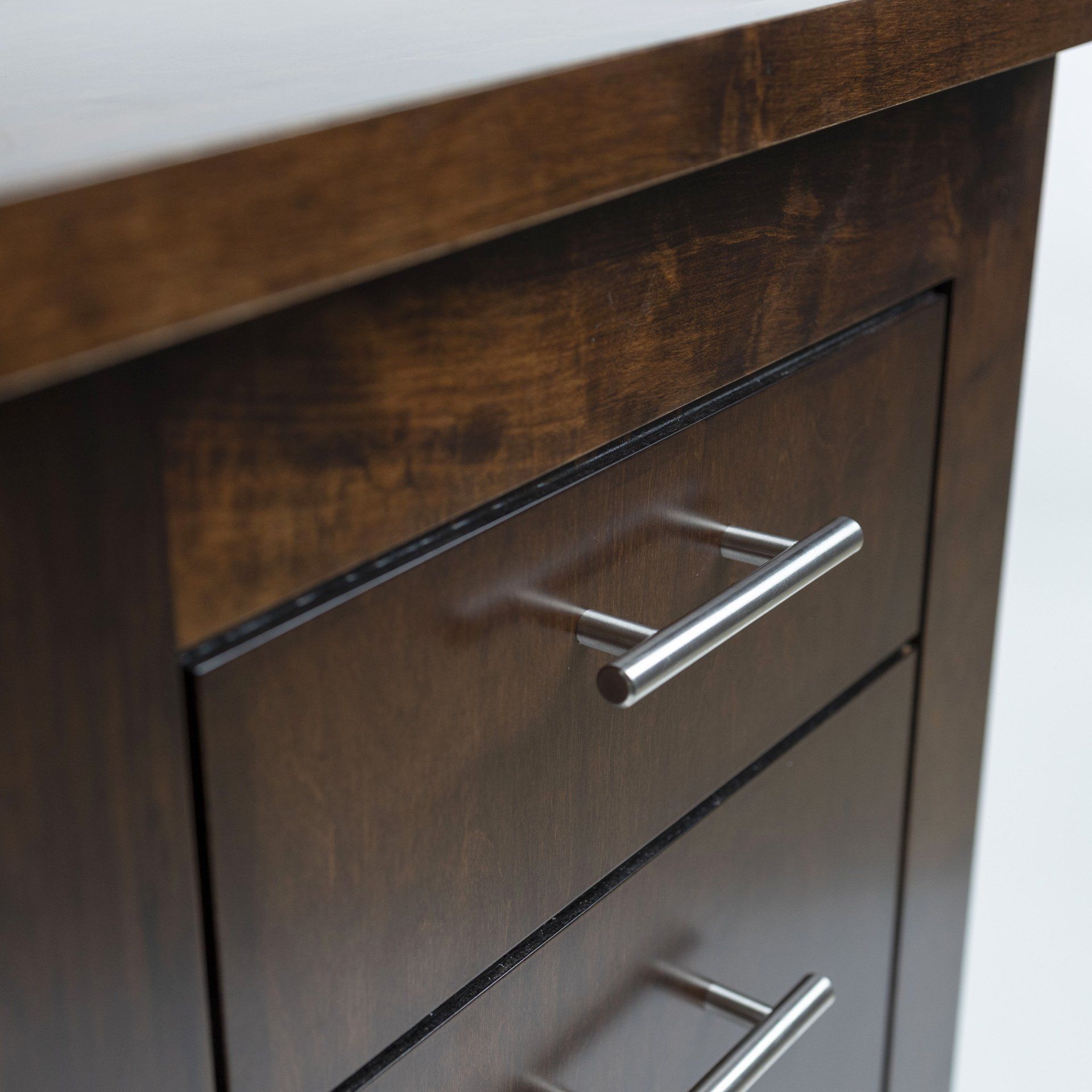 A close up of a wooden drawer with metal handles