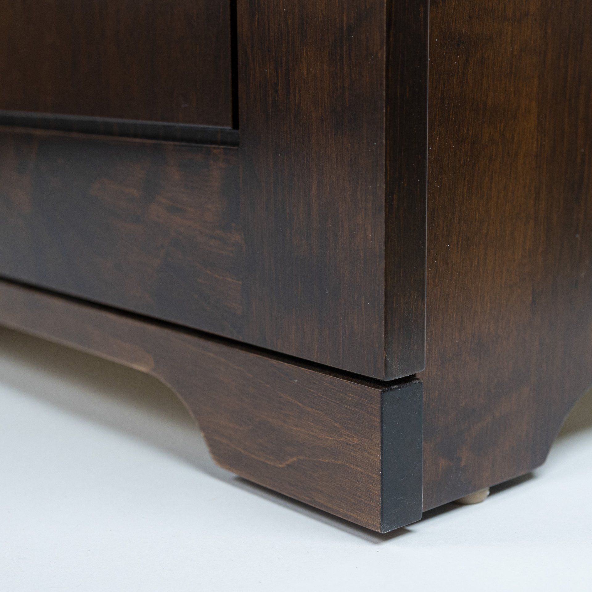 A close up of the bottom of a wooden cabinet